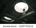 Small photo of Parkour athlete hanging from a roof top hole