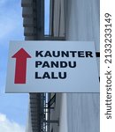 Small photo of Kaunter Pandu Lalu signage agains a blurred background. It means a Drive-through counter in English