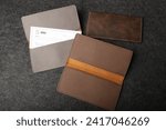 Small photo of Colorful leather checkbook. Genuine leather checkbook, concept shot, top view, different color, clamshell and stitched checkbook