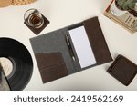 Small photo of Leather and fabric flap portfolio. Concept shot, top view, flap portfolio in different colors and leather pen. Custom background flap portfolio view. Flap portfolio and accessories.
