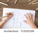Child drawing happy family on paper. Top View