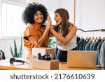 Small photo of Cheerful thrift store owners high-fiving each other in their shop. Happy young businesswomen celebrating their success as a team. Two female entrepreneurs running an e-commerce small business.