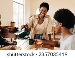 Brazilian mother serving her son drip coffee and traditional breakfast treats at home. Black family enjoying a morning meal in their kitchen, a precious moment of togetherness and happiness.
