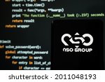 Small photo of NSO Group logo seen on smartphone placed in front of laptop with simple hacking code. Selective focus. Stafford, United Kingdom, July 19, 2021.