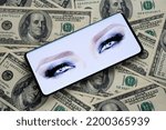 Small photo of NFT called Melania's Vision seen on the smartphone screen placed on US dollar banknotes. Marc Antoine Coulon’s watercolor pictures Melania Trump’s blue eyes. Stafford, UK, September 11, 2022.