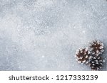 Small photo of Pine cones on a gray background with the effect of falling snow. Texture subtext