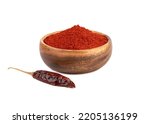 Dried peppercorns and ground smoked red paprika in a wooden bowl on a white background. Condiments and spices.