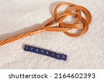 Small photo of a carpet beater with the words spanking on a white background