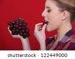 Woman eating red grapes