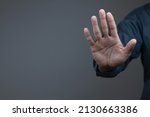 Small photo of man showing stop gesture reject on black background with empty space for text, copy space, close up of the hand, anti concept, rejection