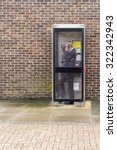 Small photo of WITHAM - ENGLAND 1ST SEPTEMBER 2015 - Man in a suit uses an modern British telephone box to make an important call in Witham England during September 2015