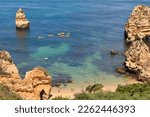 Praia do Camilo (Camilo Beach) in Lagos, Algarve region, Portugal. Beautiful and popular place with nature, calm and flat green waters, natural limestone caves and stone formations.