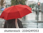 Abstract girl under red umbrella, modern city, rainy evening
