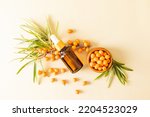 Small photo of cosmetic bottle with pipette with an organic remedy based on sea buckthorn oil against of ripe berries. skin care and nutrition. top view.