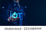 Small photo of Smart business IOT, internet of things concept. Businessman touching IOT icon on virtual screen, connected internet network to access AI intelligence, business analytics, internet investing.