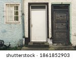 Small photo of Old doors from the past. Beautiful vintage facade depicting two old doors and one window. There must be many memories which walked in and out of those. Aged decay and rough memory retry rustic style.