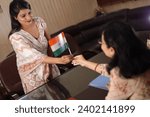 Small photo of Principal Madam giving an Indian flag to a teacher as a gift, parent teacher meeting, PTM, women, principal office, courtesy, professionalism, award.