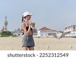 A Young Girl Feeds Seagulls