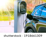 Refueling for cars e-mobility. Charging an electric car at hybrid engine gasoline and electricity. Sunlight as an electric renewable energy concept