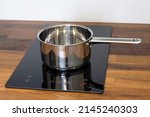 Small photo of Saucepan ladle on an induction hob built into a wooden kitchen worktop