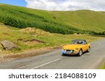 Small photo of Birkhill, Scotland - JUNE 25, 2022: 1979 Yellow MG MGB Roadster Sports car in a classic car rally en route towards the town of Moffat, Dumfries and Galloway