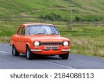 Small photo of Birkhill, Scotland - JUNE 25, 2022: 1974 Orange Ford Escort MK1 RS2000car in a classic car rally en route towards the town of Moffat, Dumfries and