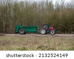 Small photo of Red Case Puma 340 tractor towing a Samson Flex-16 green muck spreader