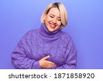Beautiful blonde plus size woman wearing casual turtleneck sweater over purple background smiling and laughing hard out loud because funny crazy joke with hands on body.