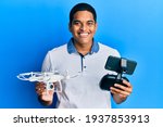 Young handsome hispanic man using drone holding remote control smiling with a happy and cool smile on face. showing teeth. 