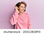 Small photo of Young brunette woman wearing casual winter sweater smiling with hand over ear listening and hearing to rumor or gossip. deafness concept.