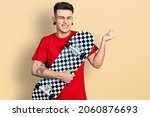 Small photo of Young caucasian boy with ears dilation holding skate screaming proud, celebrating victory and success very excited with raised arm