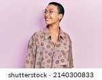 Beautiful hispanic woman with short hair wearing glasses looking away to side with smile on face, natural expression. laughing confident. 