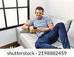 Young hispanic man smiling confident listening to music at home