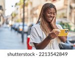 African american woman smiling confident watching video on smartphone at street