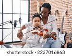 Small photo of African american mother and son student learning play violin at music studio