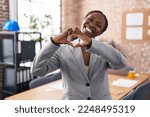 African american woman at the office smiling in love showing heart symbol and shape with hands. romantic concept. 
