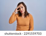 Small photo of Middle age brunette woman standing wearing orange sweater worried and stressed about a problem with hand on forehead, nervous and anxious for crisis
