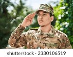 Young man army soldier saluting at park