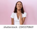 Young hispanic woman wearing casual white t shirt touching painful neck, sore throat for flu, clod and infection 