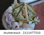 Small photo of close up view of rustic wedding ring box with floral decoration on a wooden placemat