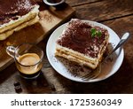 Large portion of fresh Italian tiramisu dessert served on a plate at table with espresso coffee alongside in a high angle view suitable for a menu