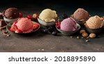 Small photo of Set of palatable appetizing ice cream scoops of various colors and favors with chocolate and berries in bowls