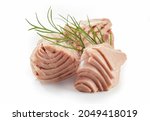 Closeup of sliced canned tuna fish fillet with sprig of fresh green dill on white background
