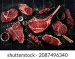Small photo of Top view set of steaks consisting of t bone sirloin ribeye tomahawk with skewers and burger patties composed with spatula spices and salt