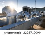 External unit of commercial air conditioning and ventilation system installed on industrial building roof. Exhaust vent on flat factory rooftop