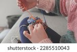 Small photo of Cute Creative Caucasian Girl Trying to Untangle Hank Skein of Yarn