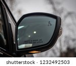 Blind Spot Monitoring system warning light/icon in side view mirror of a modern vehicle.