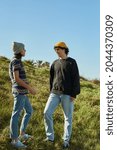 Small photo of Two rapt young people having a casual conversation while standing on a hill