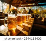 Small photo of Row of larges mugs with Beer on a table in a pub, bar or October festival grounds. Concept of beer with friends and German beer festival. Shallow field of view.