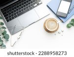 White Office desk table with laptop, supplies and coffee cup.  Space for text